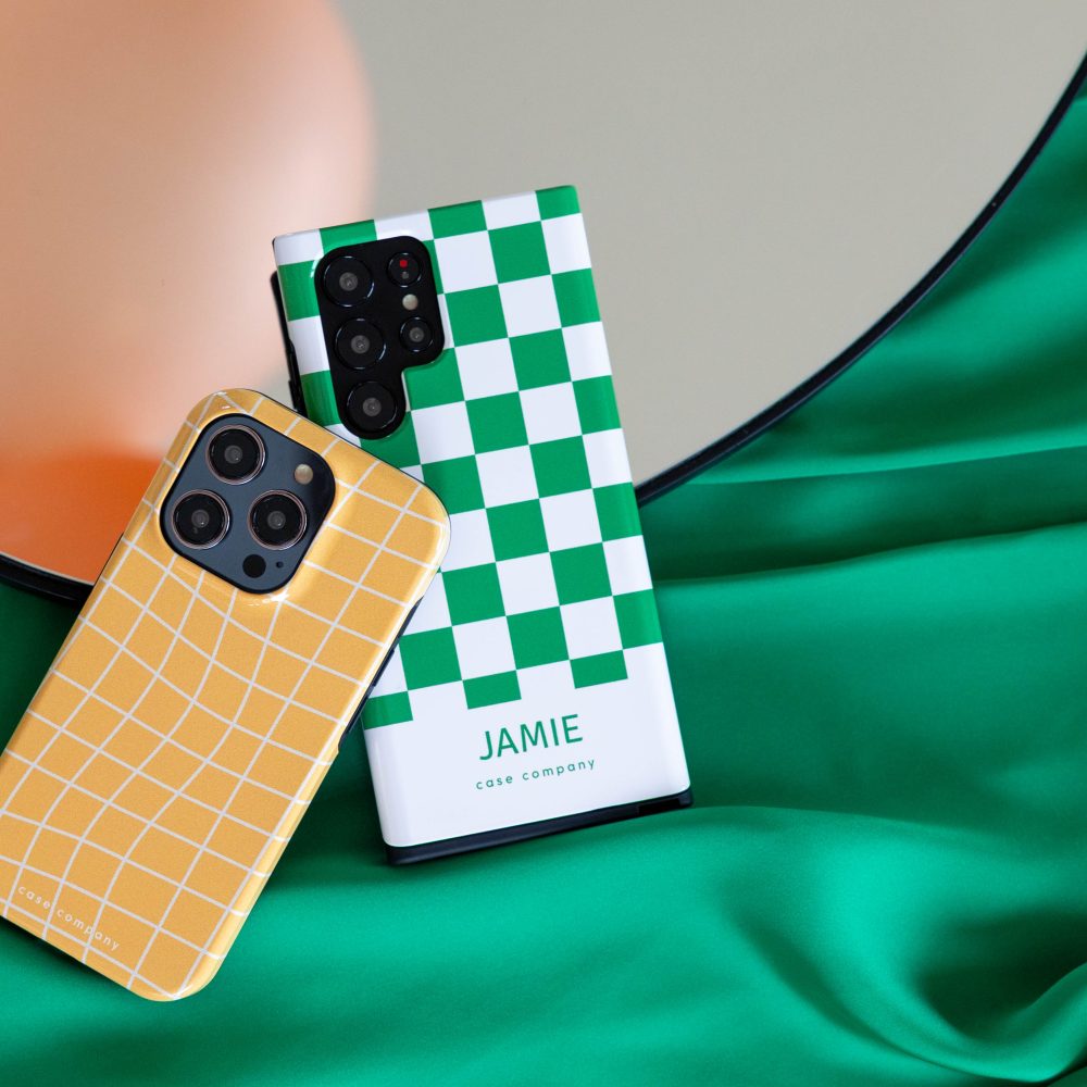 Dos fundas resistentes: una amarilla con cuadrícula para iPhone y otra con damero verde y el nombre Jamie